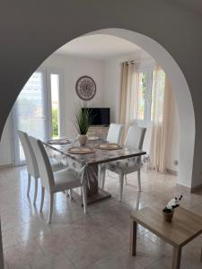 comedor con mesa y sillas en Appartement rez de villa en LʼÎle-Rousse
