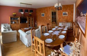 a dining room with a table and a living room at Rincón de Bachatos Casa Rural in Piedrafita de Jaca