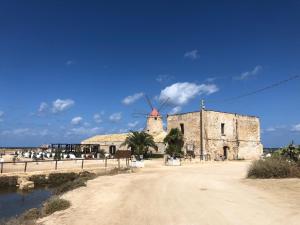 an old building with a windmill on a beach at Vicolo 35 Apartments in Trapani