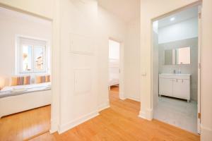 Habitación blanca con cama y espejo en GuestReady - Captain's residence R/C near Alfama, en Lisboa