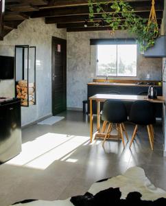 a living room with a table and two chairs at The Guest House pousada in Balneário Gaivotas
