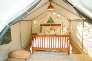 NaguaboEl Yunque Glamping River View at Casa Parcha的帐篷里有一张婴儿床的房间