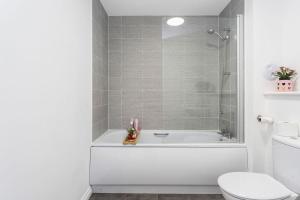 bagno bianco con vasca e servizi igienici di GuestReady - O Beehive em Edimburgo a Edimburgo