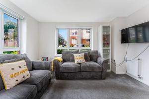 sala de estar con 2 sofás y TV en GuestReady - O Beehive em Edimburgo, en Edimburgo