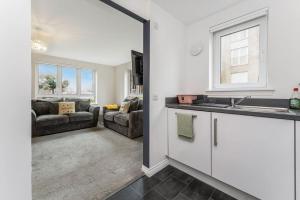 a kitchen with a sink and a living room at GuestReady - O Beehive em Edimburgo in Edinburgh