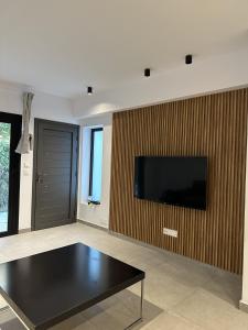 uma sala de estar com uma mesa preta e uma televisão de ecrã plano em Royal Sunset Studios & Apartments em Limassol