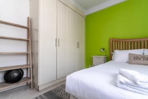 een slaapkamer met groene muren en een wit bed bij GuestReady - The Perfect Getaway in Westminster in Londen