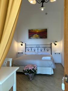 アジェーロラにあるAgriturismo Orrido di Pinoの花が飾られたベッドルーム1室