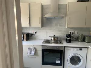a kitchen with a stove and a washing machine at 2 Bedroom Appartment in Barking +7 photos