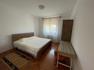 a small bedroom with a bed and a window at Apartman Goga in Pula