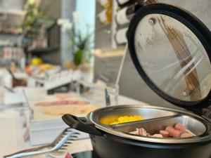 een pan met eieren en ham op een aanrecht bij Hotel Fontana Verona in Verona