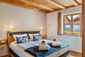 1 dormitorio con 1 cama con 2 toallas en Wohnung Blau - Ferienhaus Ammergau, en Unterammergau
