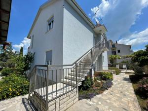 a white building with a staircase in front of it at Apartman Goga in Pula