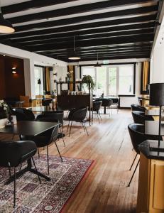 a dining room with tables and chairs and windows at Zoomers aan het Bos in Castricum +33 photos