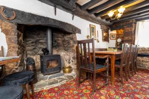 a living room with a stone fireplace and a table and chairs at New Inn in Crediton