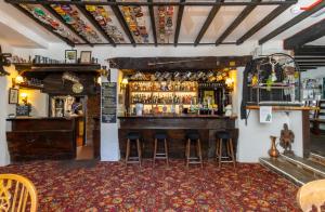 um bar num pub com bancos num quarto em New Inn em Crediton