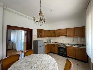 a kitchen with wooden cabinets and a table and a chandelier at Apartman Goga in Pula