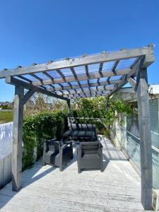 a wooden pergola with chairs and a table on a patio at Dulczetto Camp in Jastarnia