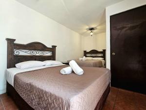 a bedroom with two beds with white pillows on them at Hotel Casa Nikté in Antigua Guatemala