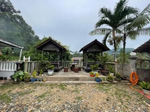 a garden with two gazebos and some plants at ACF Guest House in Sungai Lembing