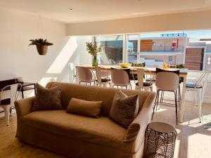 a living room with a couch and a table at Hill Sea-View Apartment in Plettenberg Bay