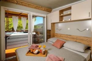 a room with a bed with a tray of food on it at Cozy and Chic Little House with Pool Ivinj-1 Vodice in Tisno