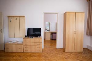 a living room with a tv and a dresser with a cabinet at Motel New Sanatron in Bosanski Novi