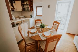 a kitchen with a wooden table with chairs and a dining room at Holiday home VITAS in Bakar