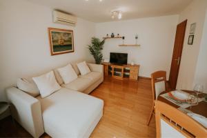 a living room with a white couch and a table at Holiday home VITAS in Bakar