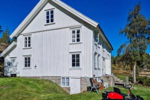 eine weiße Scheune mit einem roten Motorrad davor geparkt in der Unterkunft Flott hytte Bjelland Lindesnes in Bjerland