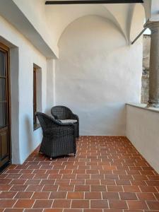 two wicker chairs sitting on a brick patio at Spillenberg House Main Property 2024 in Levoča