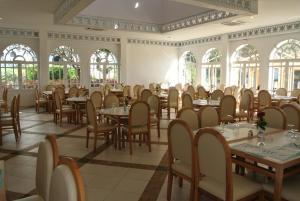 uma sala de jantar com mesas, cadeiras e janelas em Valeria Jardins d'Agadir - All In em Agadir