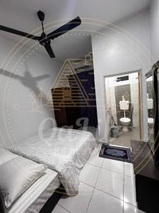 een slaapkamer met een bed en een plafondventilator bij QALIB HOMESTAY in Kuala Terengganu