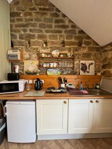 a kitchen with a counter and a stone wall at Shepherd's Hut Bilsdale in Chop Gate +27 photos