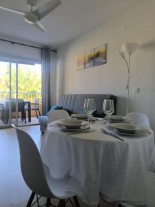 a table with a white table cloth and wine glasses at Playa, piscina, terraza, parking in Santa Pola