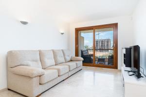 a living room with a couch and a television at Apartamento Parque Recoleta in Torrevieja