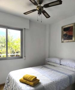 a bedroom with a bed with two yellow towels on it at Playa, piscina, terraza, parking in Santa Pola