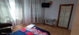 a bedroom with a bed and a television and a window at Vila Natasa&Sofia in 2 Mai