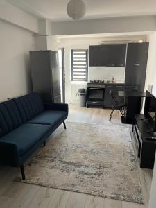 een woonkamer met een blauwe bank en een keuken bij MY LITTLE STUDIO in Craiova
