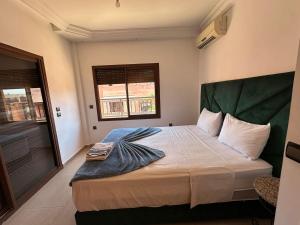 Schlafzimmer mit einem großen Bett mit einem grünen Kopfteil in der Unterkunft APPARTEMENT JAWHARA HIVERNAGE in Marrakesch