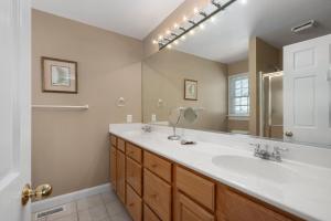 a bathroom with two sinks and a large mirror at MS22 Sandpiper's Retreat in Nags Head