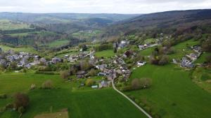 una vista aérea de un pequeño pueblo en un campo verde en Le Fagotin - Youth hostel, en Stoumont