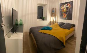 a bedroom with a bed with a yellow blanket at Maison de ville, Piscine, Jacuzzi et jardin privé in Bayonne
