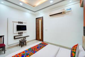 a white room with a bed and a tv at FabHotel Season Grand in New Delhi