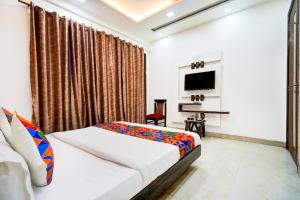 a bedroom with a bed and a flat screen tv at FabHotel Season Grand in New Delhi