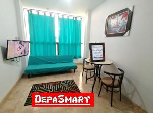 ein Wohnzimmer mit einem grünen Sofa und einem Tisch in der Unterkunft Departamento-Bolognesi B1 in Chiclayo
