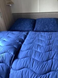 een blauw dekbed op een bed in een kamer bij RBR 135 - Beach Resort Kamperland in Kamperland