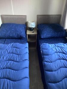 - 2 lits dans une chambre avec des oreillers bleus dans l'établissement RBR 135 - Beach Resort Kamperland, à Kamperland