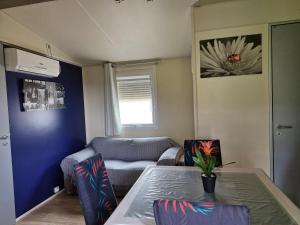 a living room with a couch and a table at Charmant mobil-home in Rocbaron