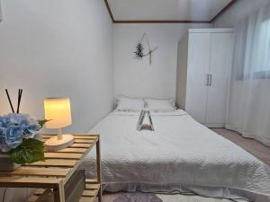 a bedroom with a bed and a table with a lamp at Green Home Stay in Seoul
